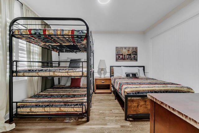 bedroom featuring crown molding and light wood-style floors