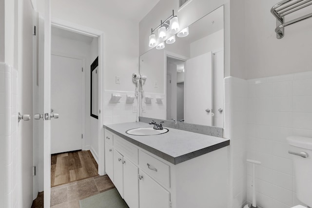 bathroom featuring vanity, tile walls, and wainscoting