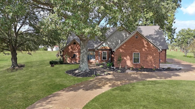 view of front of home featuring brick siding, a front lawn, and a shingled roof