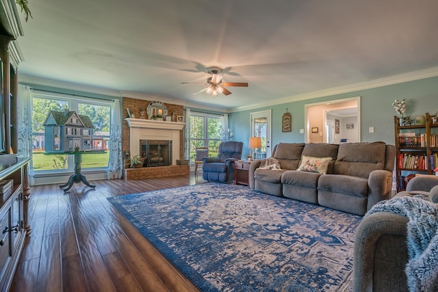 living area featuring hardwood / wood-style floors, a brick fireplace, a ceiling fan, and ornamental molding