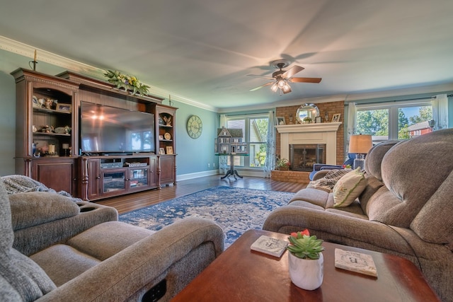 living room featuring a fireplace, crown molding, plenty of natural light, and wood finished floors