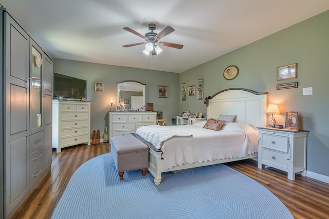 bedroom with baseboards, a ceiling fan, and dark wood-style flooring