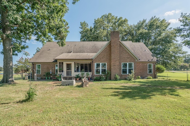back of house featuring brick siding, a chimney, a yard, and fence