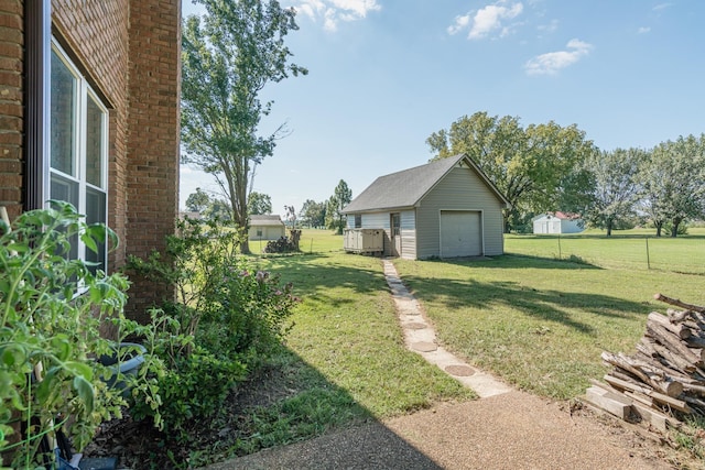 view of yard with an outbuilding, a garage, and fence
