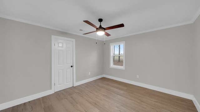 unfurnished room with crown molding, light wood-style flooring, visible vents, and baseboards