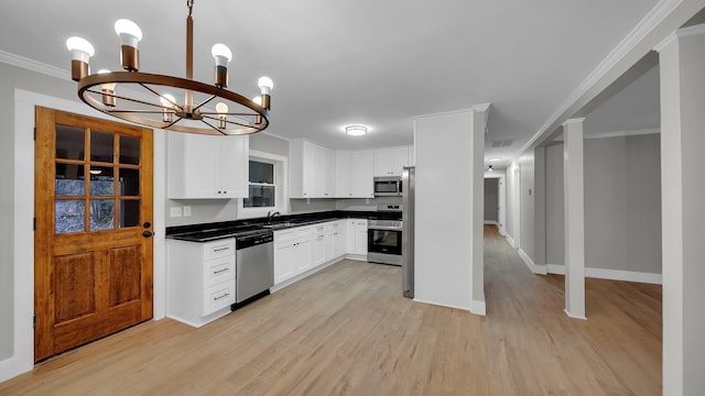 kitchen with crown molding, light wood-style flooring, dark countertops, and appliances with stainless steel finishes