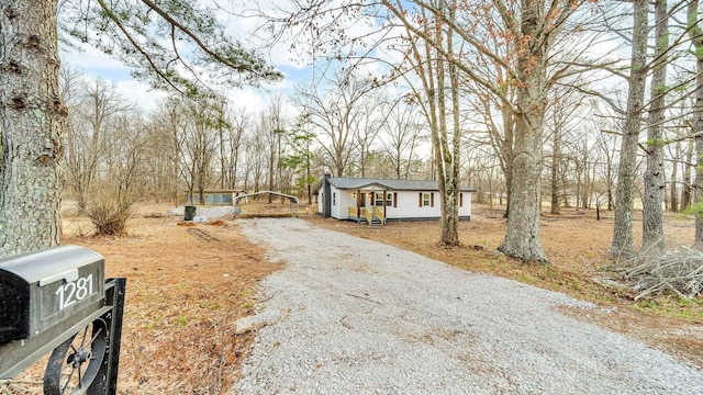 view of front of house with gravel driveway and a chimney