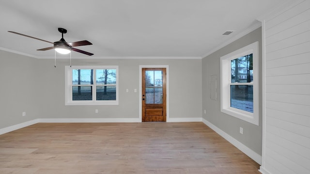 interior space with baseboards, a ceiling fan, light wood-style floors, and ornamental molding