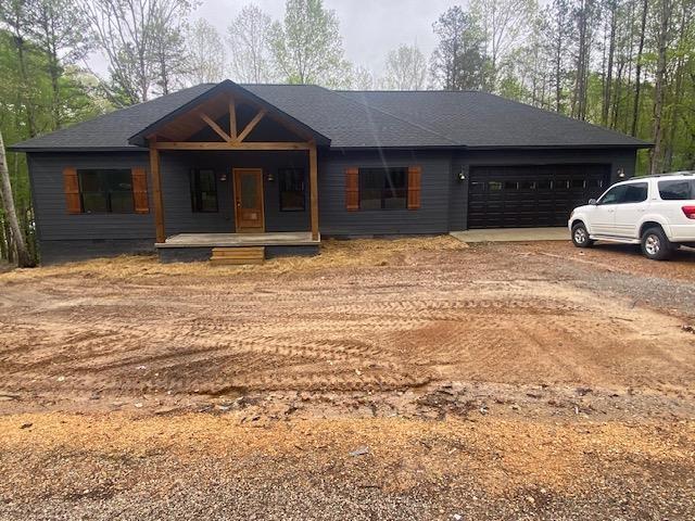 view of front of house featuring a garage, covered porch, driveway, and crawl space