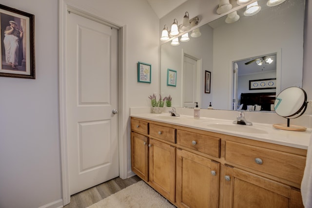 bathroom with a sink, wood finished floors, and double vanity