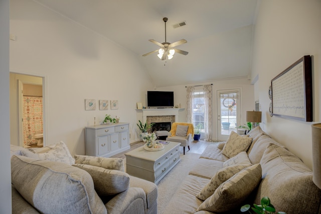 living room with ceiling fan, a fireplace, visible vents, and high vaulted ceiling