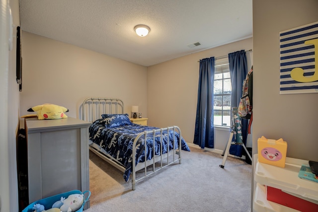 bedroom with visible vents, a textured ceiling, and carpet