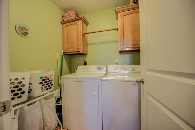 clothes washing area featuring washer and dryer, cabinet space, and a textured ceiling