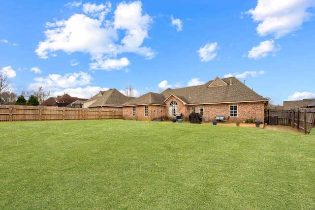 back of house featuring a lawn, a patio, a fenced backyard, cooling unit, and brick siding