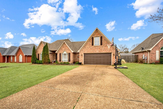 traditional-style house with a front lawn, fence, concrete driveway, a garage, and brick siding