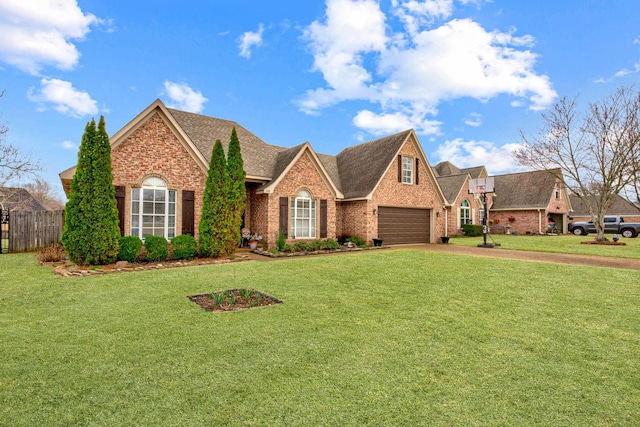 view of front of property with a front yard, driveway, a shingled roof, a garage, and brick siding