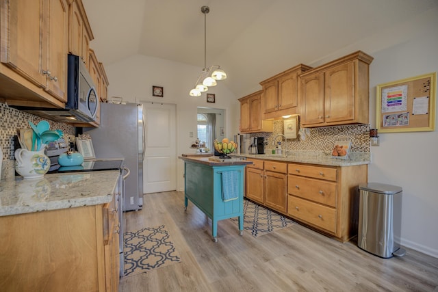 kitchen with backsplash, a kitchen island, stainless steel appliances, light wood-style floors, and lofted ceiling