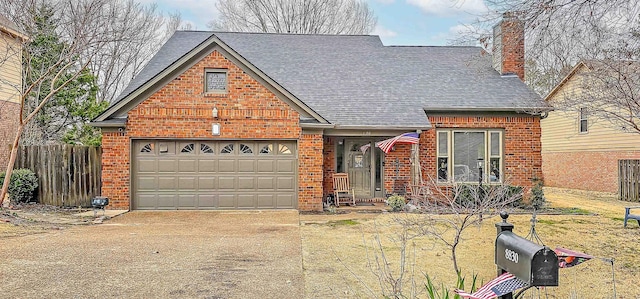 view of front facade with fence, driveway, a chimney, a garage, and brick siding