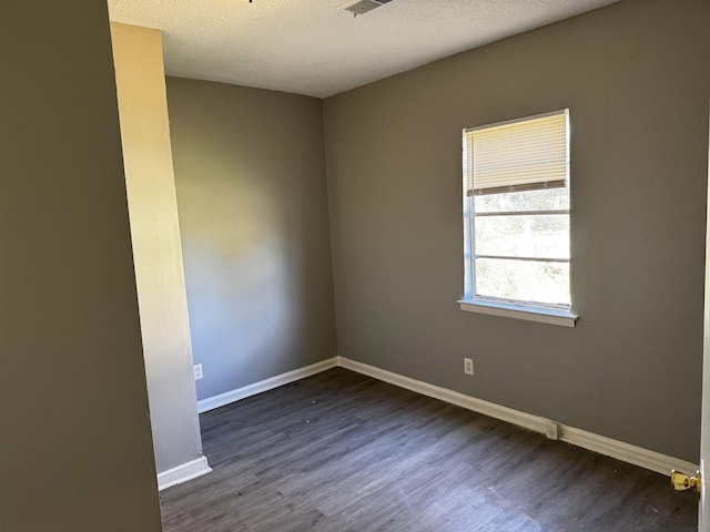 empty room with baseboards, dark wood-style flooring, and a textured ceiling