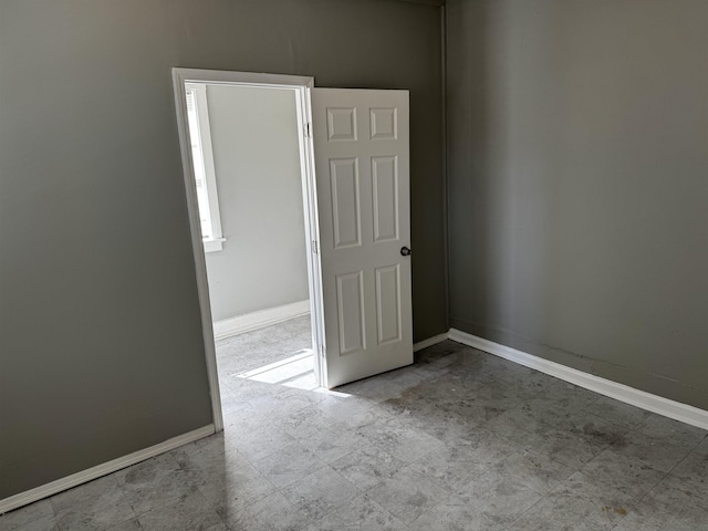 spare room with baseboards