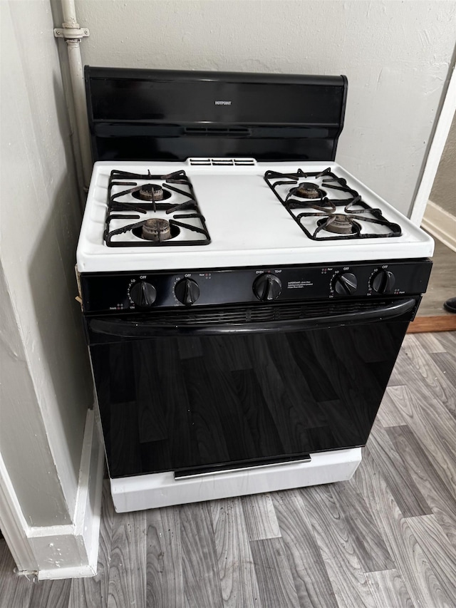 interior details with range with gas stovetop and wood finished floors