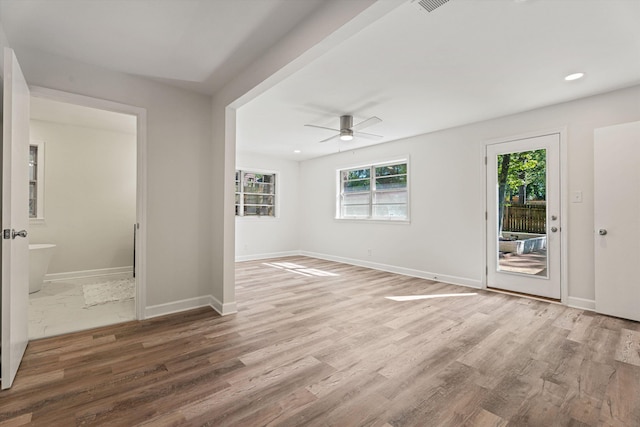 unfurnished room with plenty of natural light, baseboards, and wood finished floors