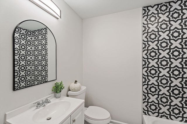 bathroom featuring vanity, toilet, and baseboards