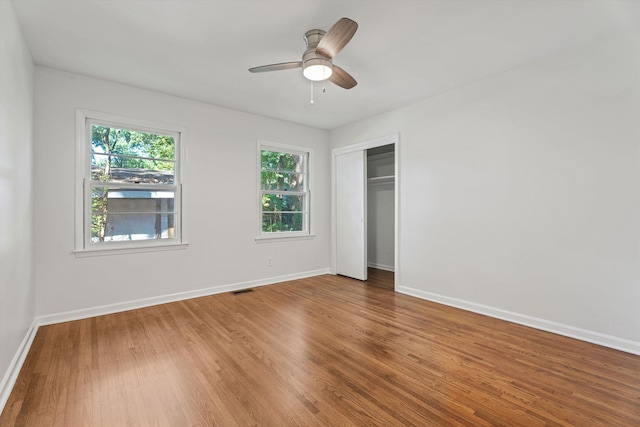 unfurnished bedroom with visible vents, baseboards, a closet, and wood finished floors