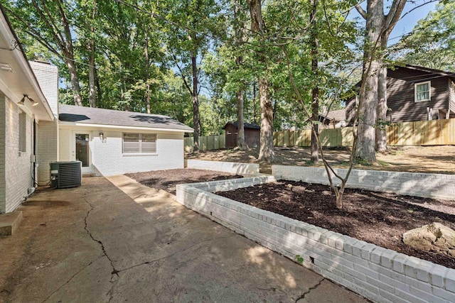 view of patio / terrace featuring cooling unit, an outdoor structure, and a fenced backyard