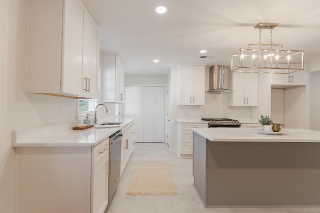 kitchen featuring a sink, recessed lighting, appliances with stainless steel finishes, wall chimney exhaust hood, and white cabinets