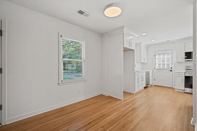 kitchen with visible vents, light wood finished floors, light countertops, white cabinets, and appliances with stainless steel finishes