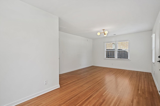 spare room with light wood-style flooring and baseboards