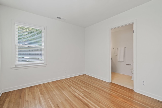 unfurnished room with light wood-style flooring, baseboards, and visible vents