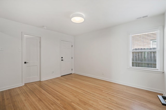 unfurnished room featuring visible vents, baseboards, and light wood-style floors