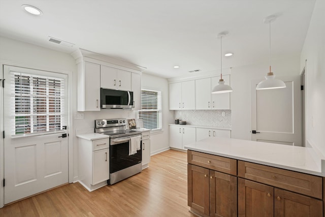 kitchen with visible vents, stainless steel appliances, light countertops, light wood-style floors, and white cabinetry