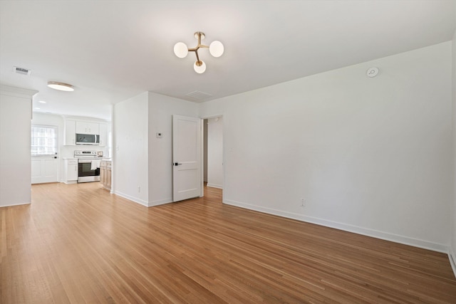 interior space with light wood-style flooring, baseboards, and visible vents