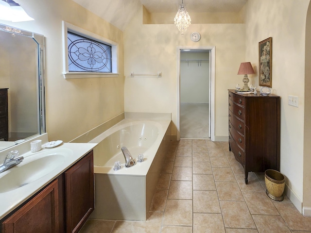 full bathroom featuring tile patterned floors, an inviting chandelier, a bath, and vanity