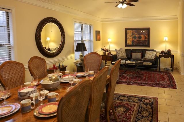 dining space with tile patterned floors, a ceiling fan, and crown molding