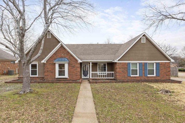 view of front of property featuring brick siding, covered porch, central AC unit, and a front yard