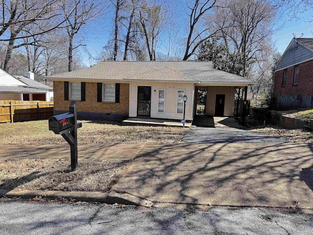 view of front of home featuring fence, brick siding, and crawl space