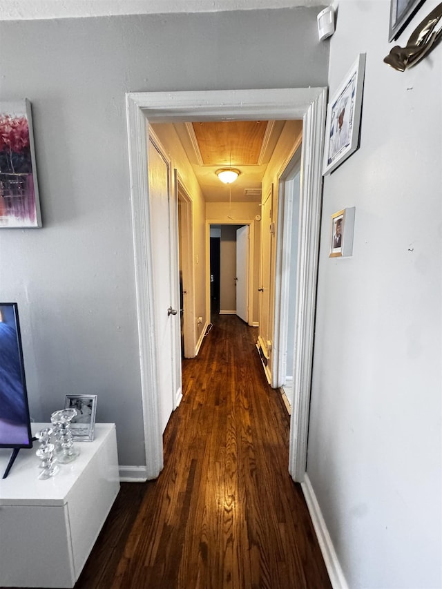 hall featuring attic access, baseboards, and wood finished floors