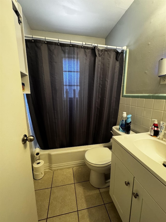 bathroom with tile patterned flooring, toilet, vanity, tile walls, and shower / bathtub combination with curtain