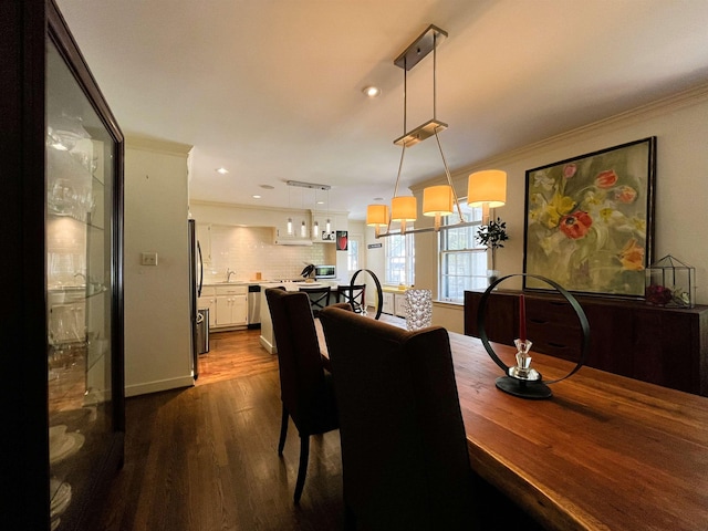 dining room featuring dark wood finished floors, recessed lighting, and ornamental molding