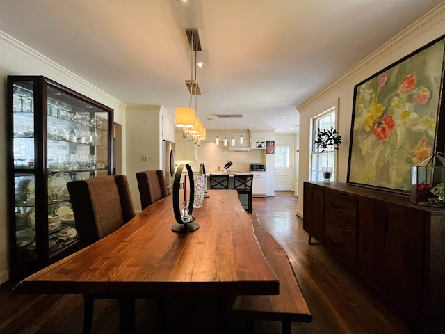 dining space featuring dark wood finished floors and ornamental molding