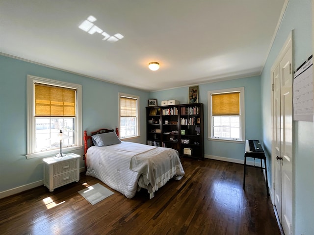 bedroom with dark wood finished floors and baseboards