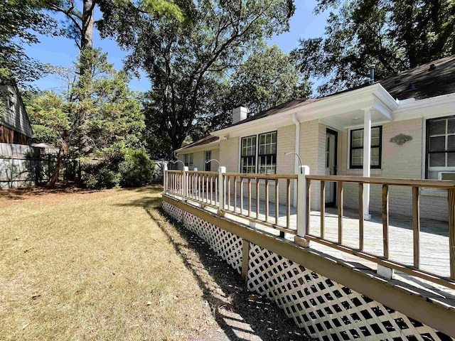 exterior space featuring brick siding, a deck, and a chimney