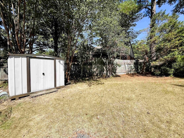 view of yard with a storage shed, a fenced backyard, and an outdoor structure