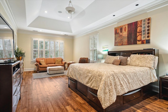 bedroom featuring recessed lighting, a tray ceiling, dark wood-style floors, and ornamental molding