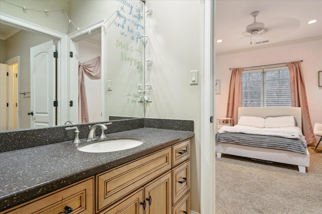 ensuite bathroom with visible vents, a ceiling fan, recessed lighting, crown molding, and vanity