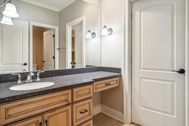 bathroom with vanity, baseboards, ornamental molding, tile patterned floors, and toilet